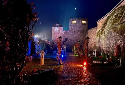 Cour du Château de Bouillon éclairée de spots colorés et décorée de tombes pour les festivités d'Halloween