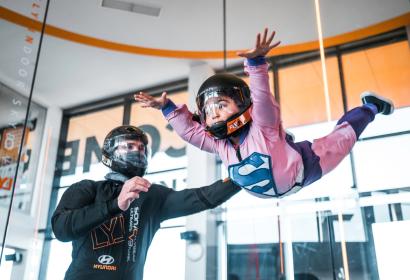 Un enfant en équilibre dans un simulateur de chute libre pour parachutiste