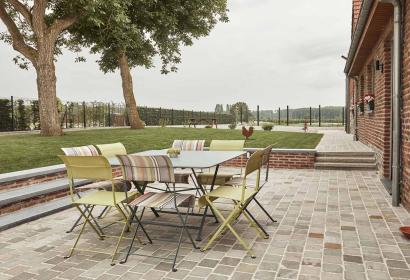Terrasse avec table et chaises de jardin du gîte Les Ganades à Brunehaut en Wallonie