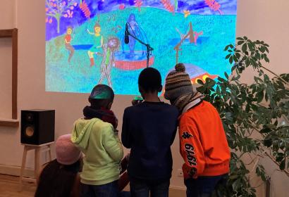 Enfants devant une oeuvre projetée sur un mur