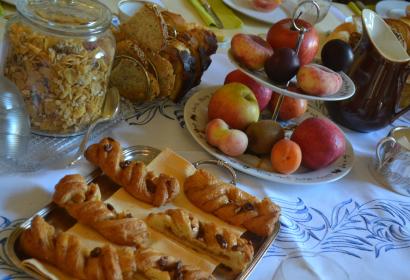 Breakfast table with fruit and chocolate braids at Le Petit Chapitre guest house in Chimay