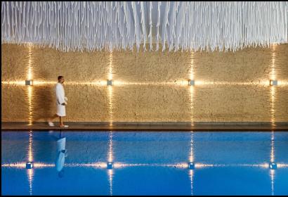 A man in a bathrobe walks by the swimming pool at the Château des Thermes de Chaudfontaine