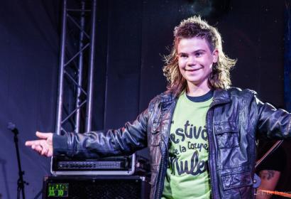 Teenager dressed in a leather jacket and wearing a mullet cut