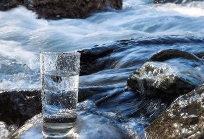 Natural water in a glass next to a river 