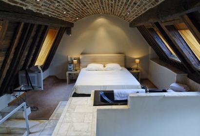 Chambre d'hôtel avec des murs en bois et un lit double de l'hôtel des Tanneurs à Namur
