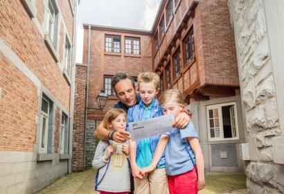Un père et ses enfants découvrent la ville de Marche-en-Famenne grâce à un carnet de jeux
