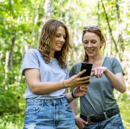 Deux copines consultent l'app VISITWallonia.be sur un smartphone