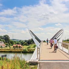 Cyclists crossing a bridge in Celles-en-Hainaut