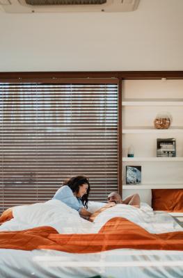Un couple est dans un lit dans l'hébergement Loft Cube au Domaine de Ronchinne