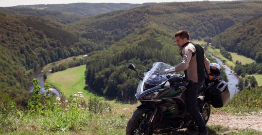 Motorradfahrer mit seinem Motorrad vor dem Aussichtspunkt 