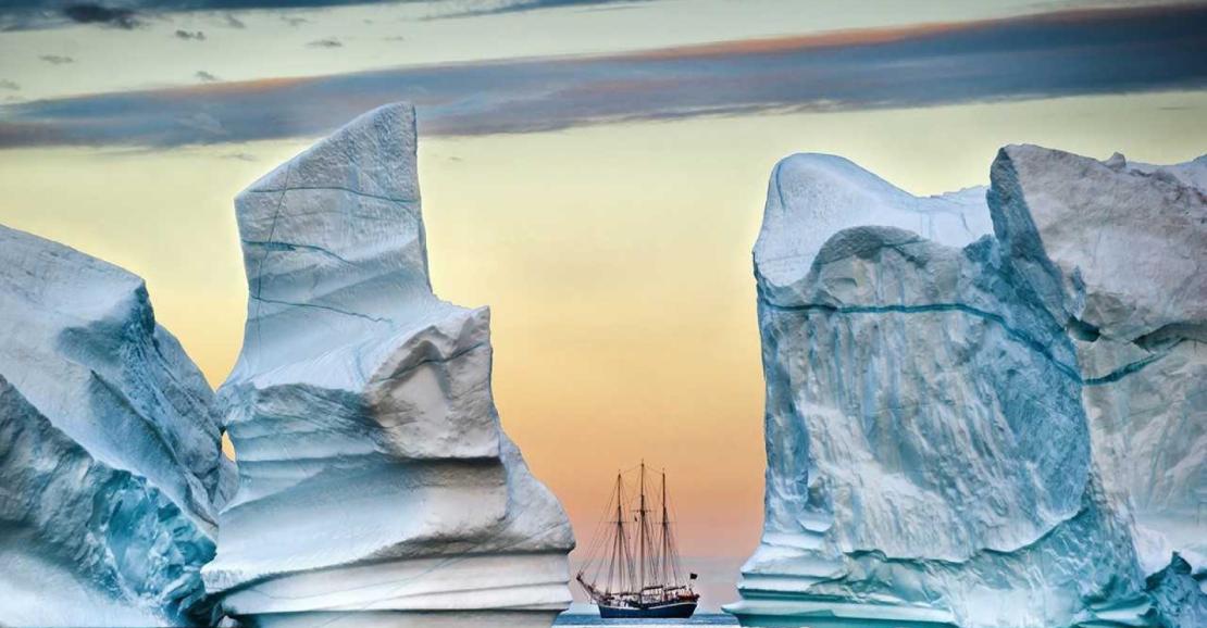 Photo d'un bâteau entre deux icebergs